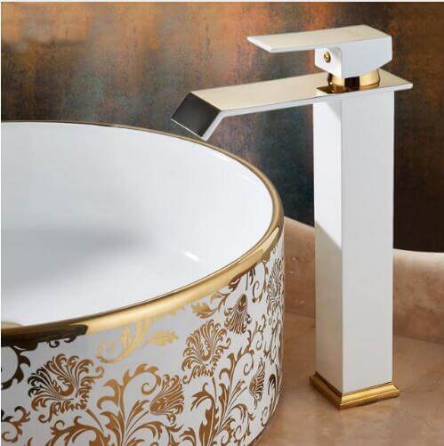 Un lavabo de baño con un grifo y un grifo dorado.